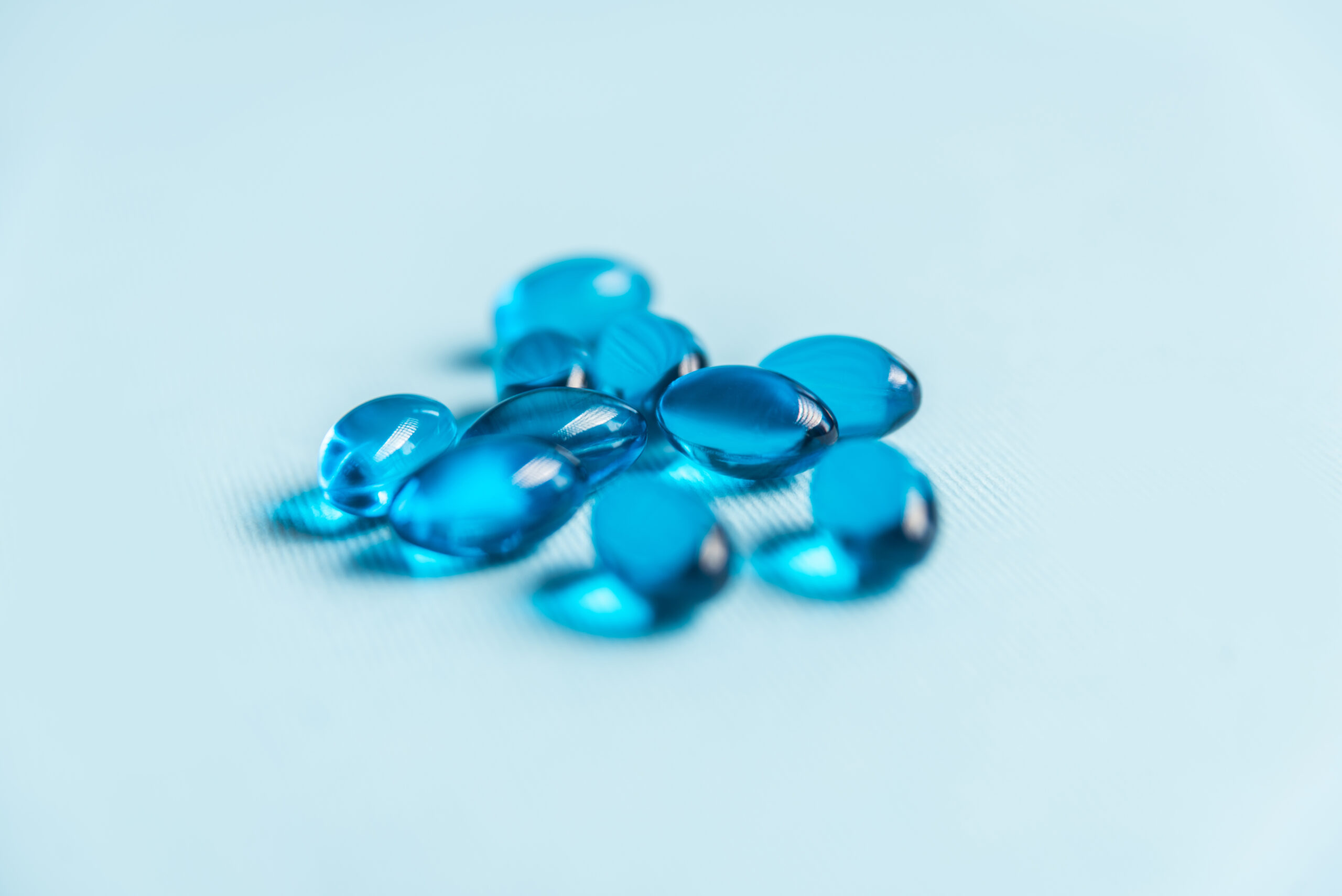 Close up of blue medical gel capsules isolated on white background